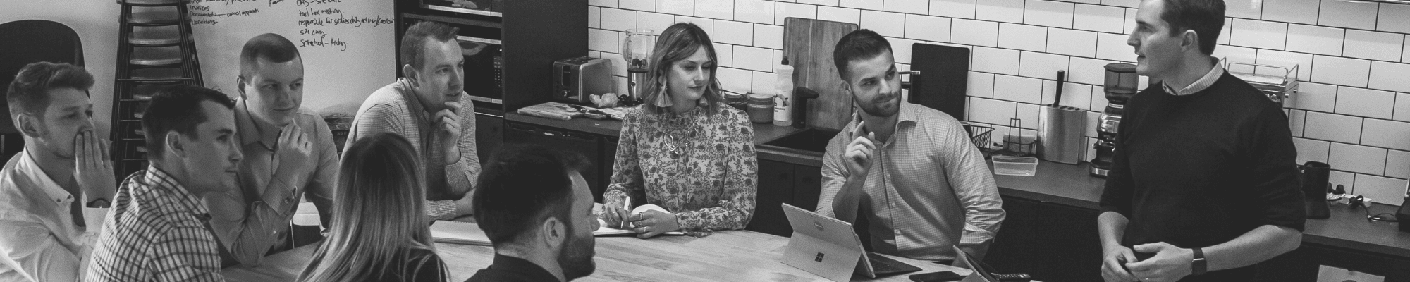 Employees of Fetch Recruitment sit around a table in their Melbourne office